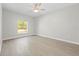 The main bedroom boasts wood-look flooring, a ceiling fan, and a bright window at 11345 Thrasher Ave, Weeki Wachee, FL 34614