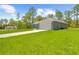 The well-maintained, light grey home features a two-car garage and extended driveway at 11345 Thrasher Ave, Weeki Wachee, FL 34614