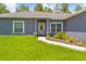 Inviting front entrance with decorative door, manicured landscaping, and a walkway at 11345 Thrasher Ave, Weeki Wachee, FL 34614