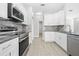 Modern kitchen with white cabinets, granite countertops, stainless steel appliances, and tiled backsplash at 11345 Thrasher Ave, Weeki Wachee, FL 34614