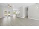 Spacious living room with wood-look tile floors and view into the kitchen and hallway at 11345 Thrasher Ave, Weeki Wachee, FL 34614
