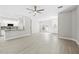 Open-concept living room with wood-look floors adjacent to a modern kitchen with white cabinets at 11345 Thrasher Ave, Weeki Wachee, FL 34614