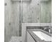 Walk-in shower with gray tile and granite vanity; shower includes built-in shelving at 11345 Thrasher Ave, Weeki Wachee, FL 34614