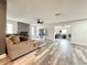 Spacious living room with gray-toned wood floors, a ceiling fan, and a view to an office space at 11472 Kerridale Ave, Spring Hill, FL 34608