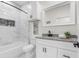Bathroom with white tile and cabinets, granite countertop, and black fixtures at 12706 N Ola Ave, Tampa, FL 33612