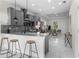 Modern kitchen with gray cabinets, stainless steel appliances, a marble countertop, and an island with bar stool seating at 12706 N Ola Ave, Tampa, FL 33612