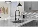 Close up on a modern sink with gooseneck faucet and gray cabinets at 12706 N Ola Ave, Tampa, FL 33612