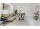 Inviting living room with neutral tones, plants, stylish furniture, a large window for natural light, and marble floors at 12706 N Ola Ave, Tampa, FL 33612