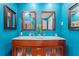 This bright bathroom features a wood cabinet, dual sinks and turquoise walls at 12757 Circle Lake Dr, Hudson, FL 34669