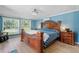This primary bedroom has an ornate wood bed frame, a ceiling fan and a window at 12757 Circle Lake Dr, Hudson, FL 34669
