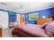 Comfortable bedroom with two windows, blue walls, decorative art, and natural wood furnishings for a cozy and stylish retreat at 12757 Circle Lake Dr, Hudson, FL 34669