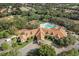An aerial view of the clubhouse, pool, parking lot, landscaping, trees, and surrounding homes at 150 Center Oak Cir, Spring Hill, FL 34609