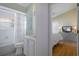Bathroom with shower-tub combo next to a bedroom with wood floors and TV at 150 Center Oak Cir, Spring Hill, FL 34609