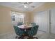Light-filled dining area with a round table, floral chairs, and a ceiling fan at 150 Center Oak Cir, Spring Hill, FL 34609