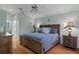 Well-lit main bedroom with hardwood floors, a ceiling fan, and matching nightstands at 150 Center Oak Cir, Spring Hill, FL 34609