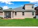Rear exterior of the house with a screened-in porch, manicured lawn and windows at 1801 Loch Haven Ct, Trinity, FL 34655