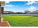 Lush green backyard with a white fence and view of neighboring houses at 1801 Loch Haven Ct, Trinity, FL 34655