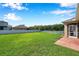 Spacious backyard with lush green lawn, a white fence, and access to the screened-in patio at 1801 Loch Haven Ct, Trinity, FL 34655