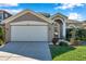 Charming home exterior featuring a two-car garage, manicured landscaping, and a welcoming front entrance at 1801 Loch Haven Ct, Trinity, FL 34655