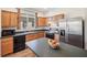 Kitchen with stainless steel appliances, wood cabinetry, and a convenient island counter at 1801 Loch Haven Ct, Trinity, FL 34655
