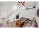 Bright living room with wood floors, ceiling fan, high ceilings, and stairway to the second floor at 1801 Loch Haven Ct, Trinity, FL 34655