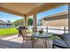 The covered patio has an outdoor table, chairs, and grill with a view of the backyard at 1801 Loch Haven Ct, Trinity, FL 34655