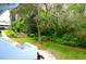 Green backyard with lush landscaping and condo building at 1955 Abrico Dr # G12, Lutz, FL 33558
