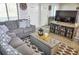 Cozy living room featuring gray sofa with patterned pillows and an entertainment center at 1955 Abrico Dr # G12, Lutz, FL 33558
