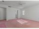 Bright bedroom features pink carpet, ceiling fan, and natural light streaming through the window at 2171 Whitewood Ave, Spring Hill, FL 34609