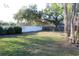 Well-maintained backyard with lush green grass, mature trees, and privacy fence at 2233 Egret Walk Ct, New Port Richey, FL 34655