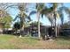 An outdoor living space with a screened enclosure, a fire pit, and lush greenery at 2233 Egret Walk Ct, New Port Richey, FL 34655