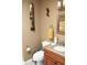 Tan bathroom featuring granite vanity, mirror, toilet, and African themed art at 2233 Egret Walk Ct, New Port Richey, FL 34655