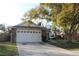 Spacious home with a two-car garage and a large tree in the front yard at 2233 Egret Walk Ct, New Port Richey, FL 34655