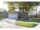 Inviting front yard featuring mature trees and a spacious driveway leading to the garage at 2233 Egret Walk Ct, New Port Richey, FL 34655