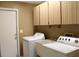 Bright laundry room with washer, dryer, utility sink, and ample cabinet space at 2233 Egret Walk Ct, New Port Richey, FL 34655