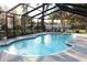 A beautiful screened-in swimming pool with a cool deck and furniture for relaxing poolside at 2233 Egret Walk Ct, New Port Richey, FL 34655