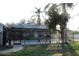 The home features a screened-in pool, an outdoor living space, and mature trees at 2233 Egret Walk Ct, New Port Richey, FL 34655