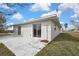 Back of a home featuring stucco walls, large sliding glass doors, and a concrete patio with outdoor space at 3449 Companero Entra, Hernando Beach, FL 34607