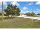 The exterior of a single-story home with a long driveway and a large tree in the front yard at 3449 Companero Entra, Hernando Beach, FL 34607