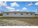 The side of a single-story home with multiple windows and gray stucco at 3449 Companero Entra, Hernando Beach, FL 34607
