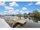 A view of a long canal featuring docks and waterfront homes under a partly cloudy sky at 3449 Companero Entra, Hernando Beach, FL 34607