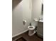 Bathroom showcasing dark wood-look flooring and a white toilet and vanity at 3801 Kimball Ave, Tampa, FL 33614