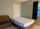 Bedroom featuring tiled flooring, a cozy wicker chair and a queen-sized bed near a window covered by a green curtain at 3801 Kimball Ave, Tampa, FL 33614