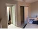 Neutral-toned bedroom showcasing a closet and an ensuite bathroom with a shower, complemented by tiled flooring at 3801 Kimball Ave, Tampa, FL 33614