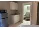 Compact kitchenette featuring a mini-fridge, microwave, and sink with white cabinetry, adjacent to a full bathroom at 3801 Kimball Ave, Tampa, FL 33614
