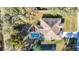 Aerial view of a home with a pool and lush landscaping in a serene residential neighborhood at 469 Fairbanks Rd, Spring Hill, FL 34608