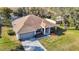 Scenic aerial view of a home with pool, lush yard, and a well-maintained two-car garage and driveway at 469 Fairbanks Rd, Spring Hill, FL 34608
