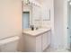 Well-lit bathroom vanity with white cabinets, a mirror, and stylish sink fixtures at 469 Fairbanks Rd, Spring Hill, FL 34608