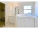 Bright bathroom featuring a walk-in tub, single sink vanity, and open closet space at 469 Fairbanks Rd, Spring Hill, FL 34608