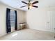 Neutral bedroom with a ceiling fan, window with dark curtains and a small vanity at 469 Fairbanks Rd, Spring Hill, FL 34608